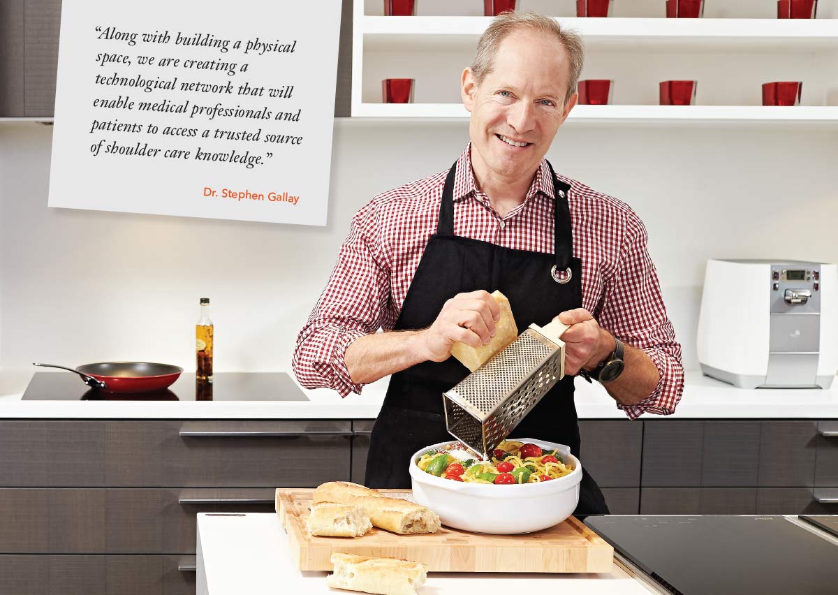 Smiling surgeon shredding cheese over pasta serving bowl in the kitchen
